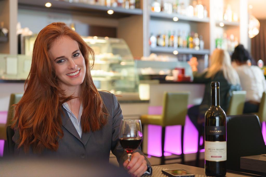 Leonardo City Tower Hotel Tel Aviv Giv'atayim Dış mekan fotoğraf A woman drinking wine